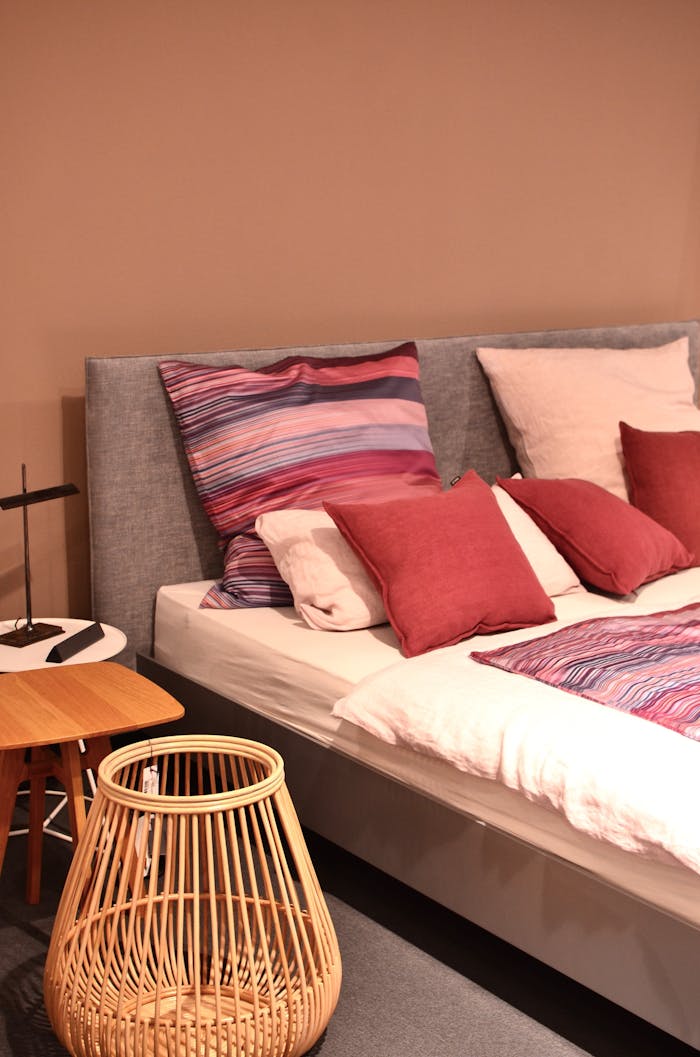 services-04 Stylish bedroom scene with colorful pillows, a rattan basket, and modern decor for a cozy interior.